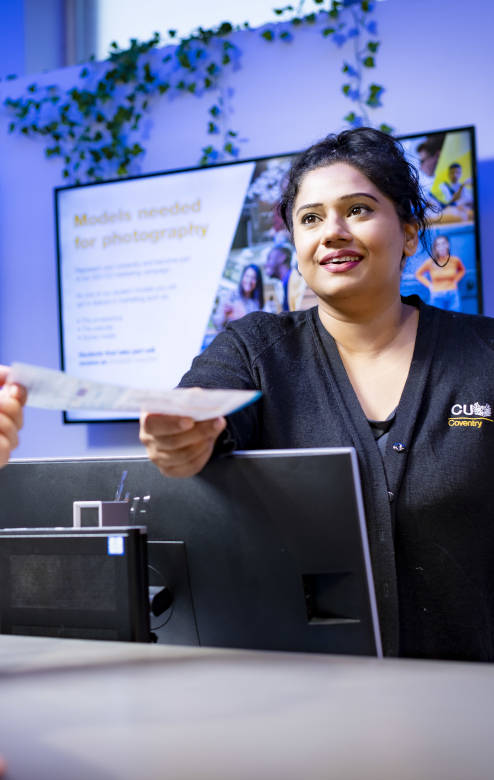 CU Coventry staff member handing over a piece of paper