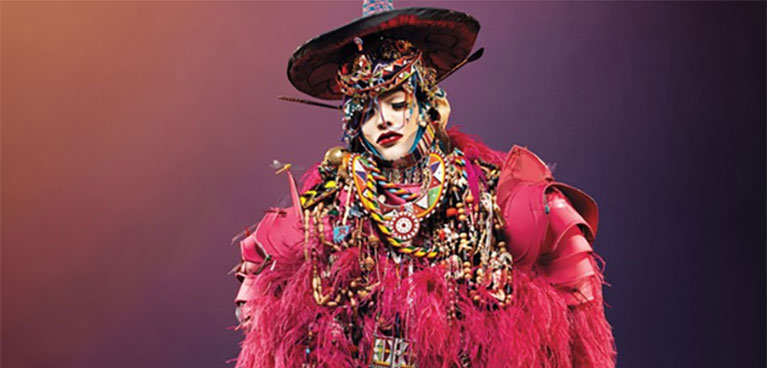 Artistic image of a person dressed in jewels and pink feathers