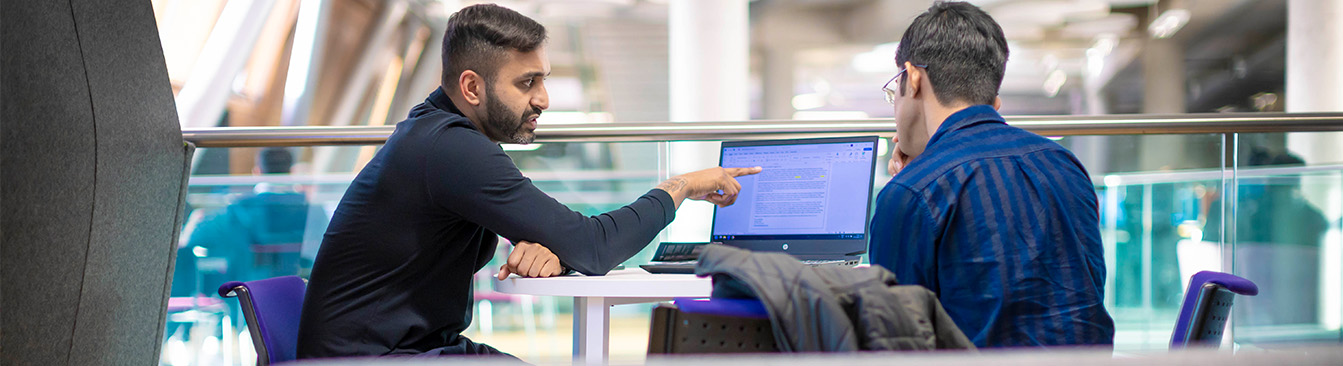 two men working at a computer station