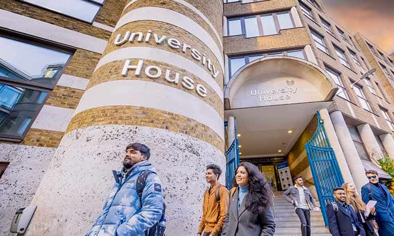 Students walking by Coventry University London campus building University House