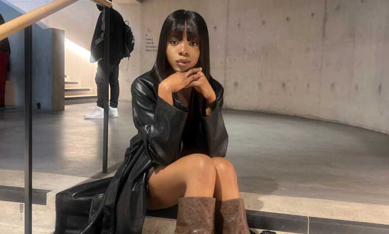 International Fashion management student Laura Momodu sitting on stairs