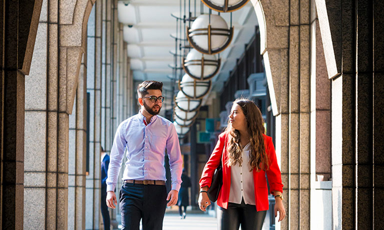 Two students walking through the London campus