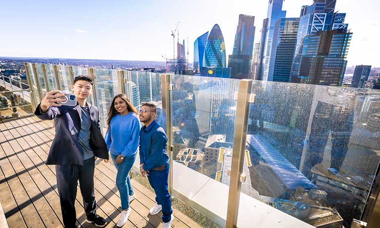 Students in a tall building overlooking the London skyline.