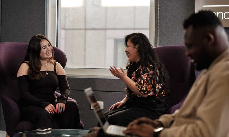 students in a relaxed area chatting 