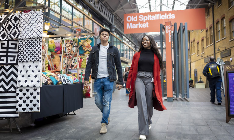 Two students walking through Old Spitalfields Market together.