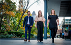 Three students walking through the City of London with the Gherkin Building in the background