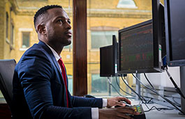 Student working on two computer screens in a big PC room 