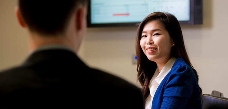 Woman talking to a man in a seminar room