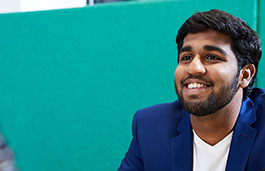 Adult male wearing a blue jacket smiling while looking at the camera