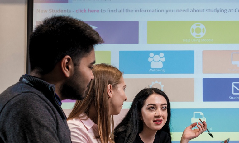 Three students working in a classroom