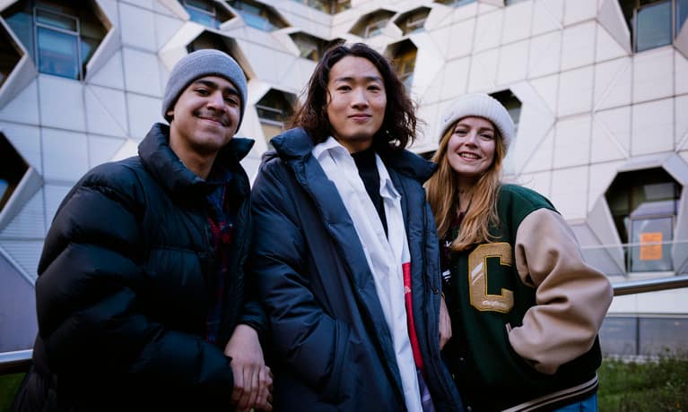 Three students outside the Frank Whittle Building
