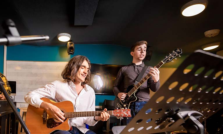 Two musicans playing guitars 