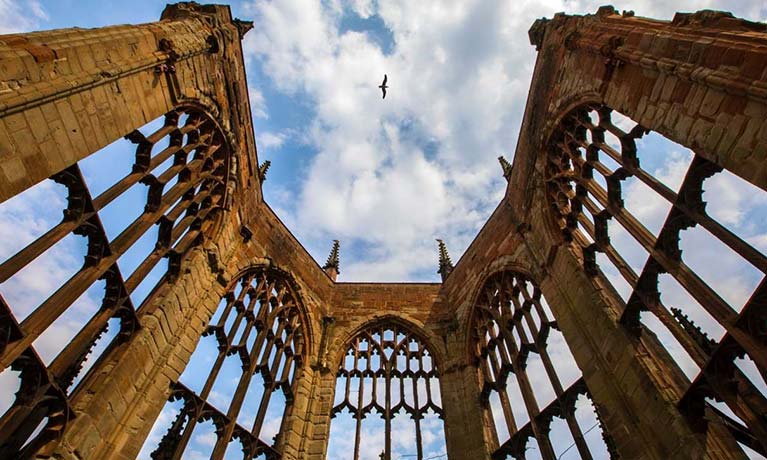 Coventry cathedral ruins with a clear sky and a bird flying over