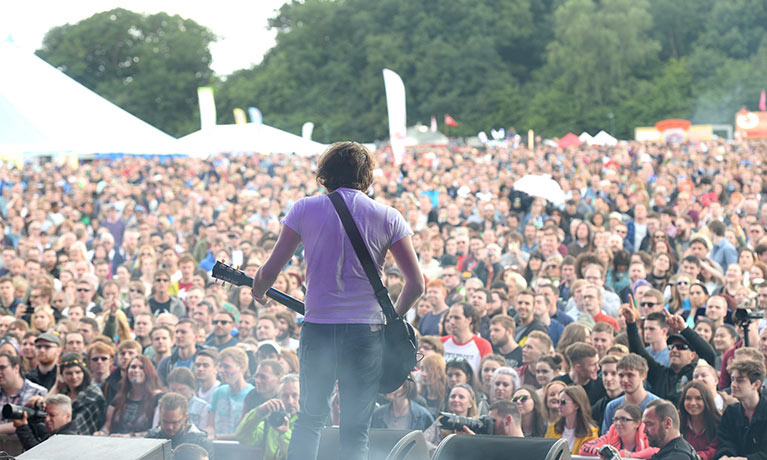 A performer on the Godiva Festival stage, looking out at the audience