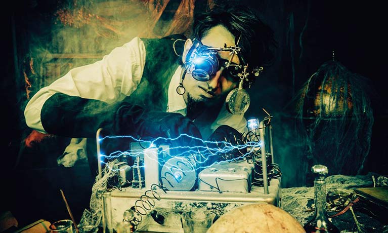scientist with equipment on his head working on a machine in a dark shabby room
