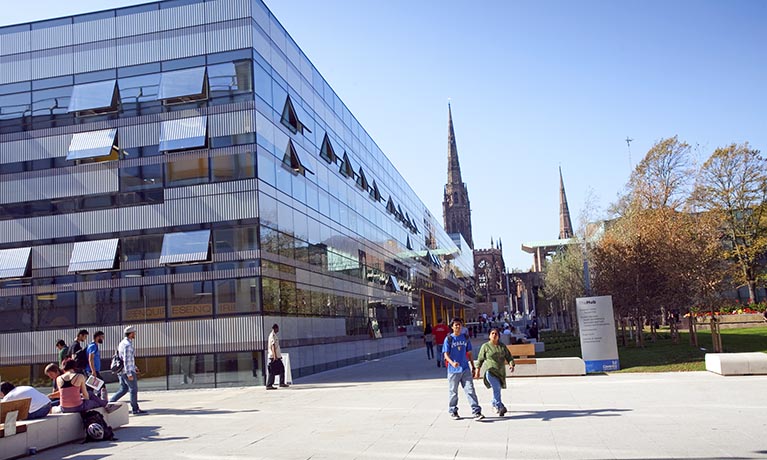 Glass modern building with a spire in the background