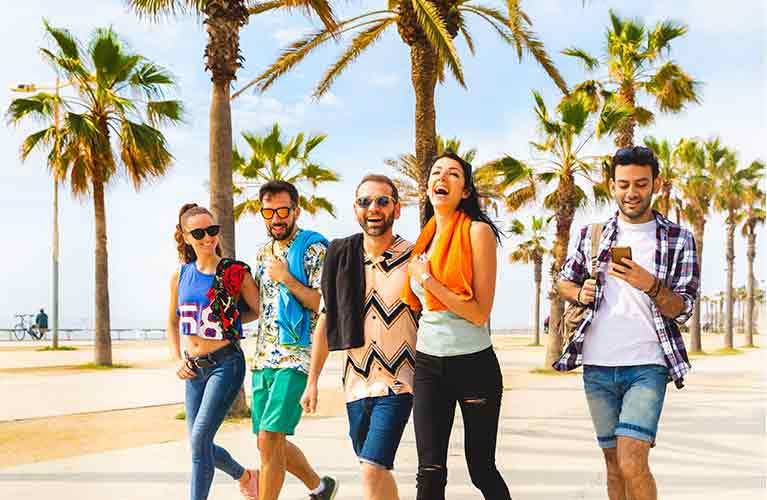 A group of people laughing with palm trees in the background