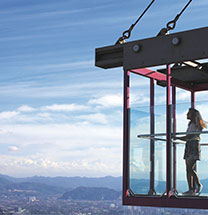 Woman in glass observatory seeing the mountains