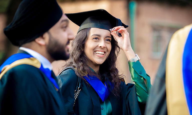 female graduate wearing a graduation cap smiling 