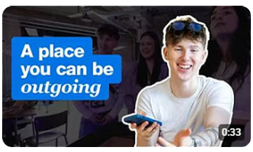 student smiling holding a phone