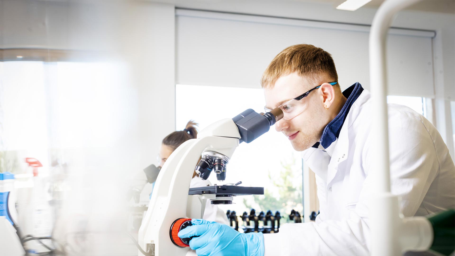 Student using a microscope in a laboratory.
