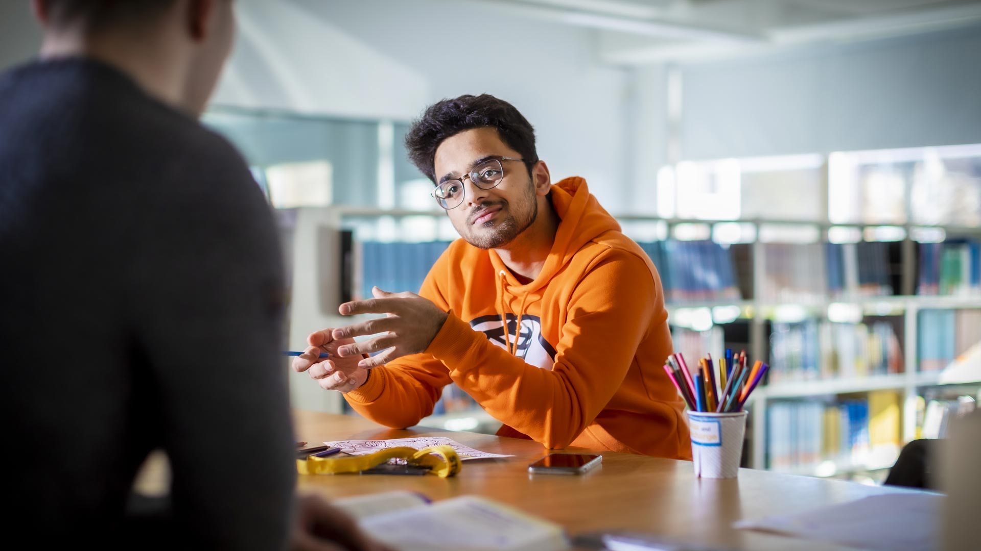Students talking in a library.