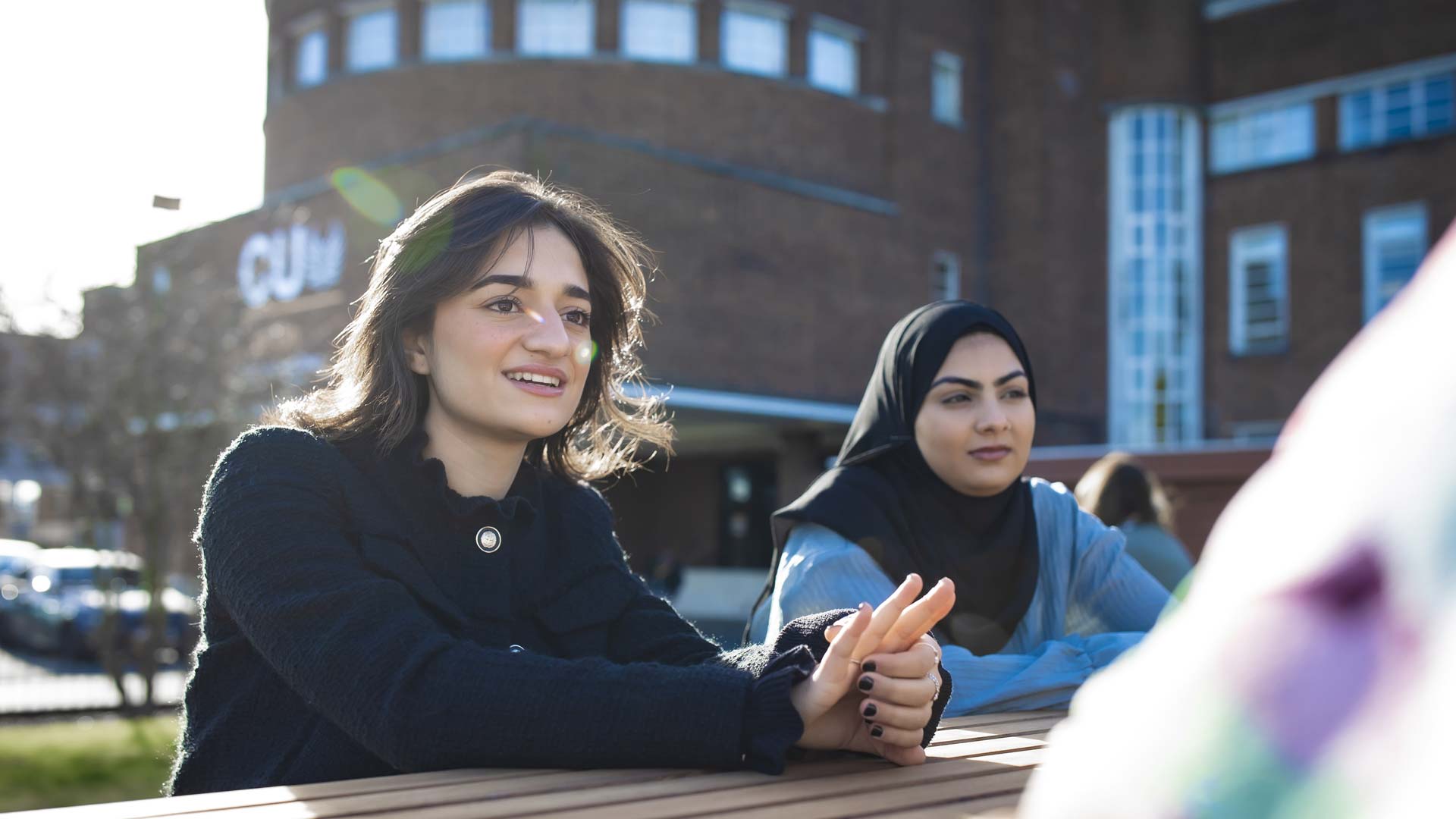 A group of students sat outside the CU London Dagenham building.