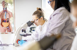 Biosciences students using microscopes in a laboratory.