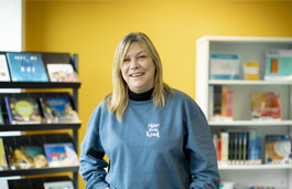 Student in the library wearing a 'raise them kind' sweatshirt.