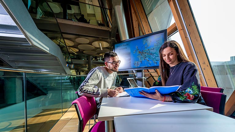 A man and woman sitting at a table in the Sir Frank Whittle Building