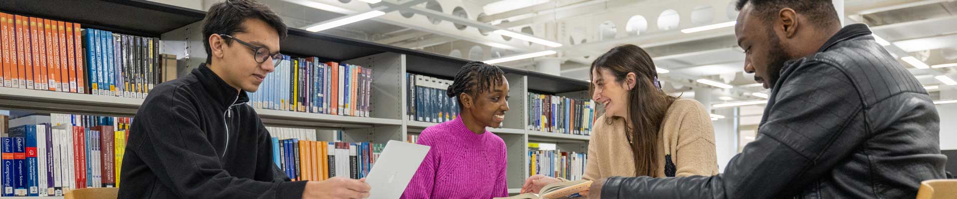 Four students in a library working together