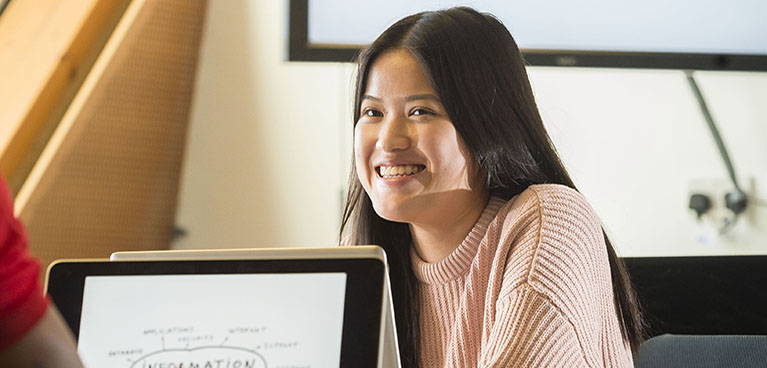 Smiling student using a laptop