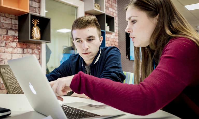 students working together on a macbook