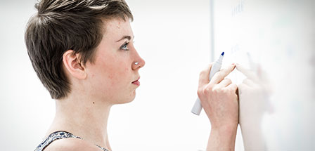 female writing on a white board