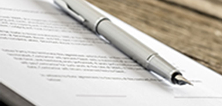 a fountain pen rests on an out of focus document