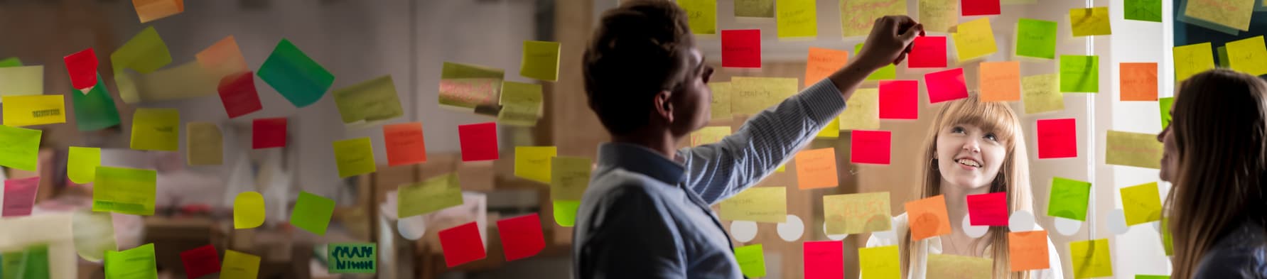 Student looking at a Perspex screen covered in coloured post it notes