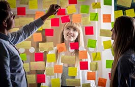 Student looking at a Perspex screen covered in coloured post it notes