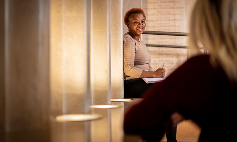 female sitting with row of lights