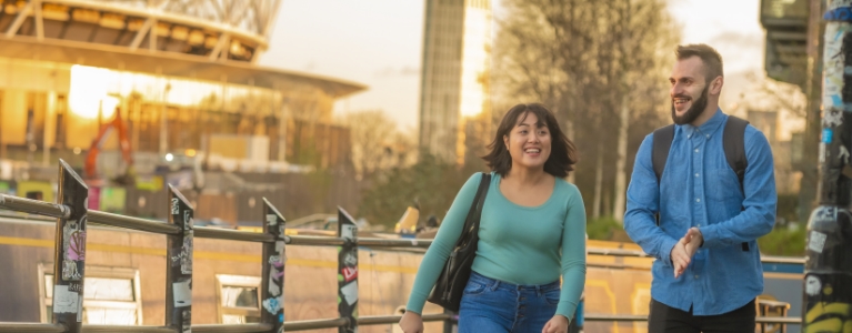 Man and woman outside smiling in the city