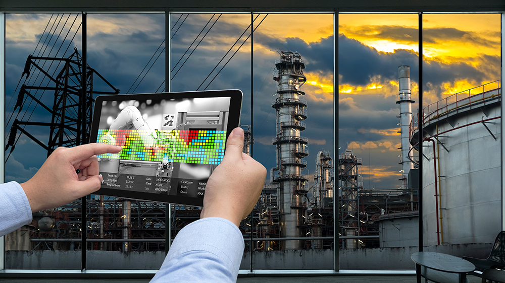 Analysing data on a tablet while looking out over a power plant