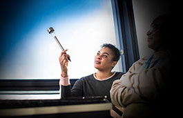 Student sat in front of a window holding a thin light