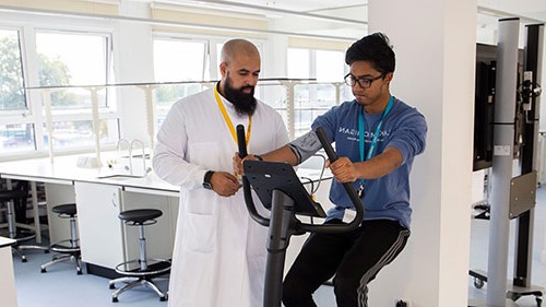 Two Public Health students using an exercise bike for testing