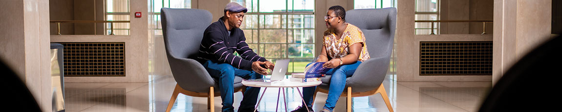 Two students sat down having a chat inside