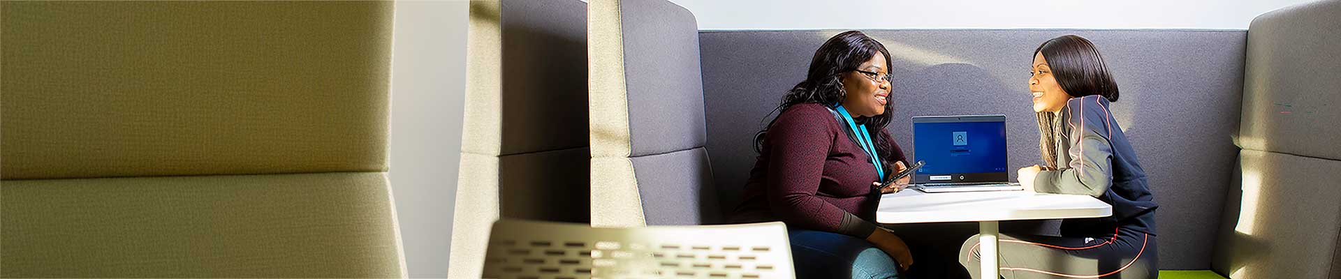 Two students sat in a pod talking
