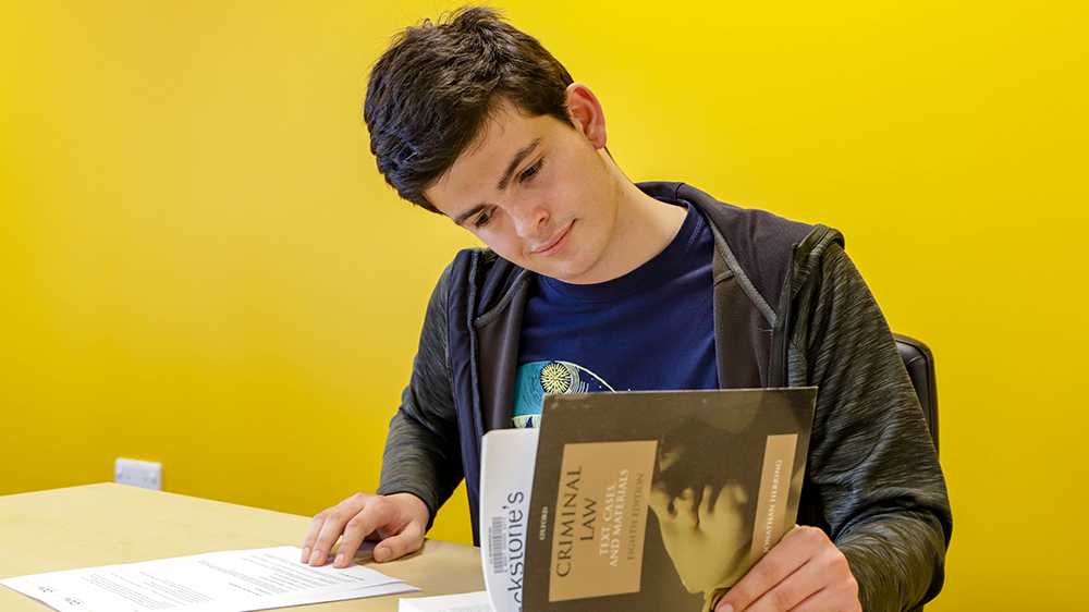 Law student studying a course book