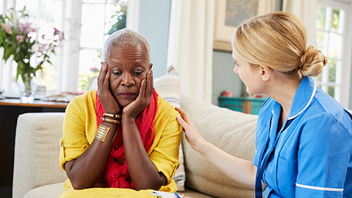 Nurse comforting an older lady