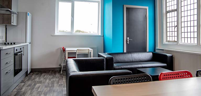 Large sofa in a dining area next to a kitchen