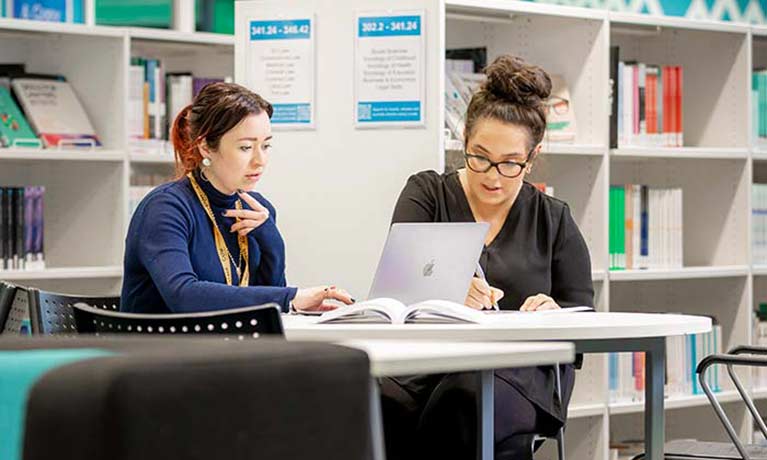 Two students working in the library