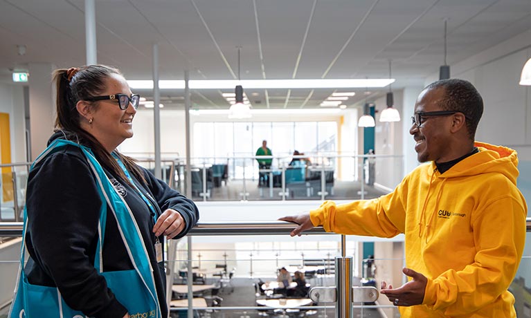 Two students stood facing each other talking