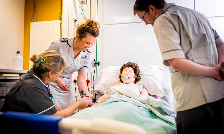 Student Nurses studying with a mock patient